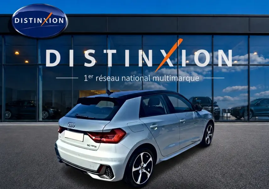 Audi A1 Sportback 30 TFSI gris arrow avec toit noir, vue 3/4 arrière mettant en valeur le becquet et les jantes alu.
