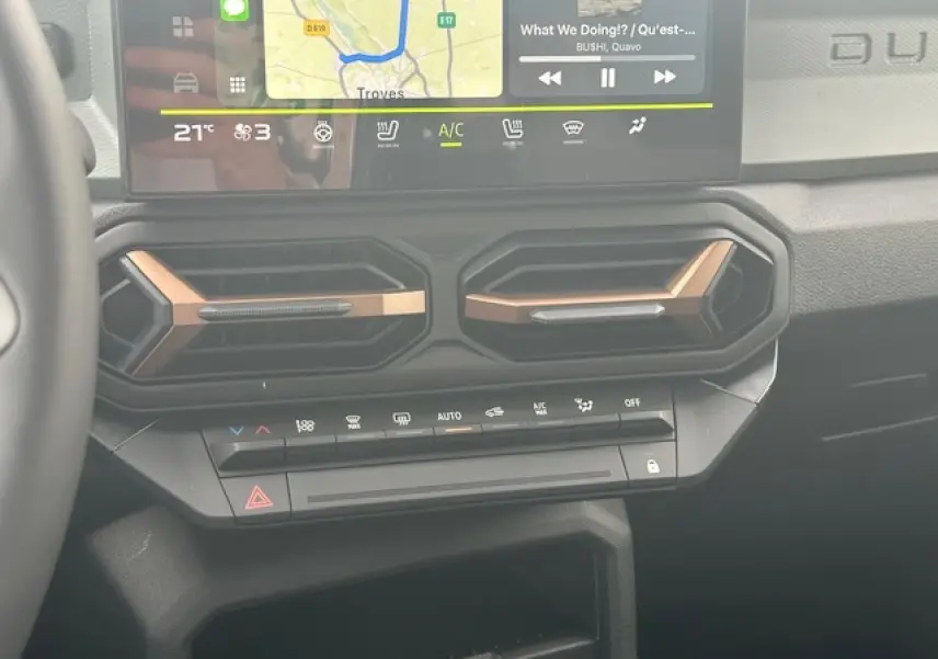 Détail du tableau de bord du Dacia Duster III 2025, montrant les aérateurs hexagonaux et l'écran tactile central.