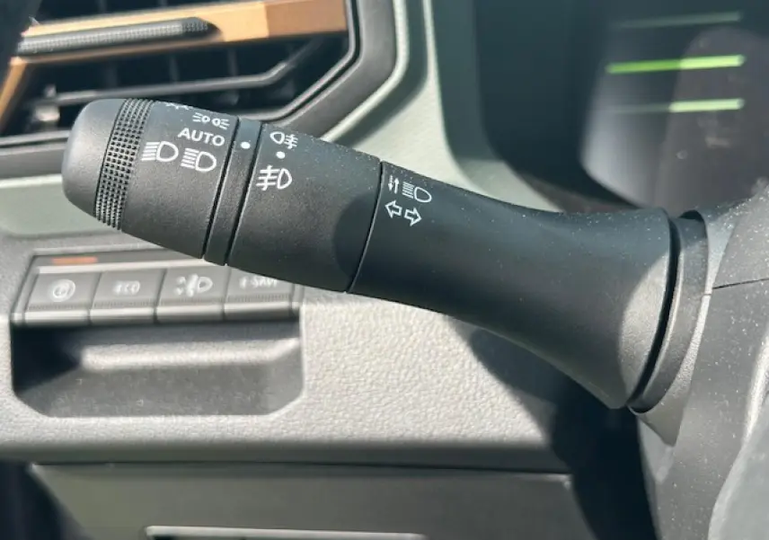 Gros plan sur la commande des feux et clignotants à gauche du volant du Dacia Duster gris schiste 2025.