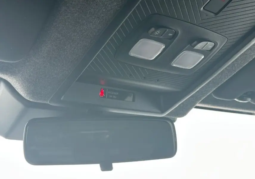 Vue en contre-plongée du plafonnier noir et du rétroviseur intérieur du Dacia Duster gris schiste 2025.
