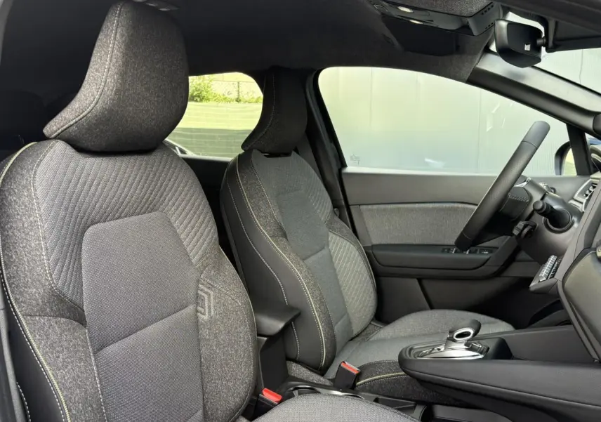 Intérieur avant du Renault SYMBIOZ noir étoile, sièges tissu gris avec surpiqûres jaunes et console centrale moderne.