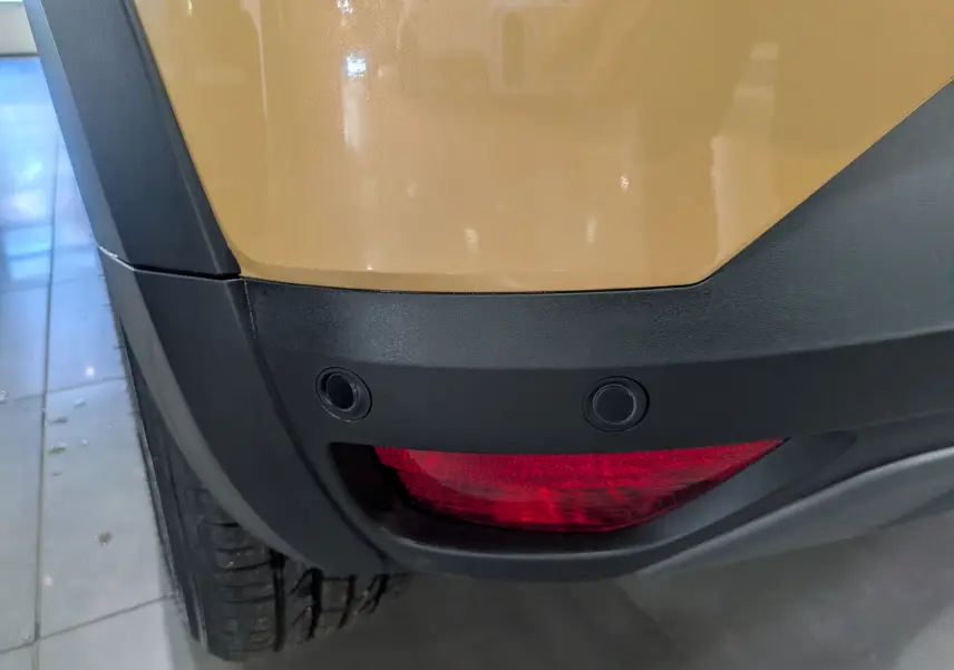 Gros plan sur le feu arrière droit beige Safari du Dacia Sandero Stepway 2025 avec capteurs de recul intégrés.