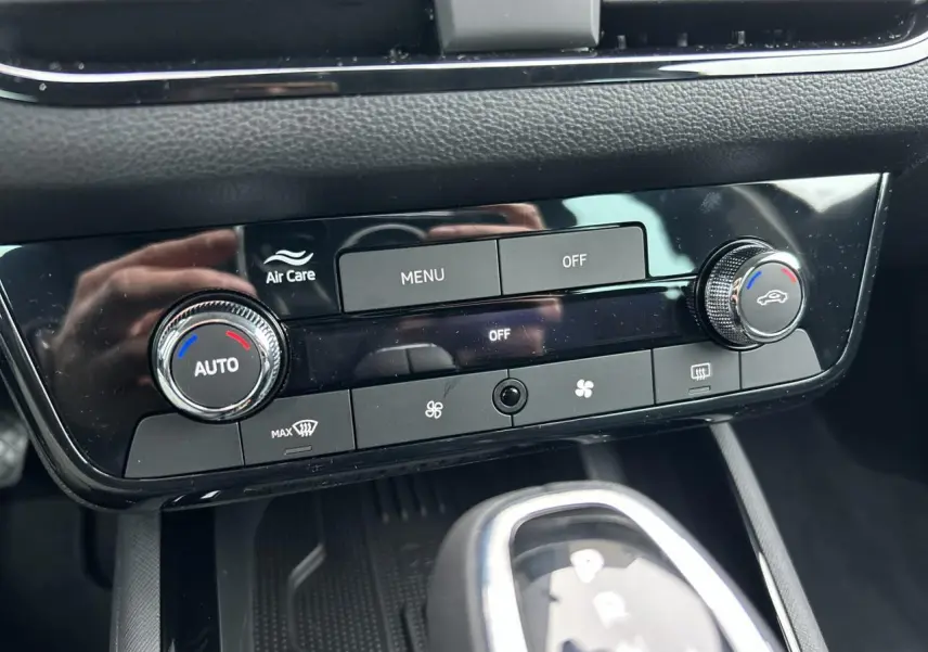 Gros plan sur la console centrale du Skoda Kamiq noir, montrant la climatisation automatique et le levier de boîte automatique.