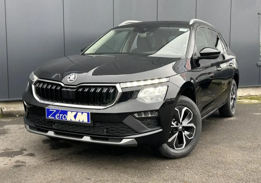 Vue 3/4 avant droite d'un Skoda Kamiq noir Magic avec jantes alliage et calandre chromée brillante.
