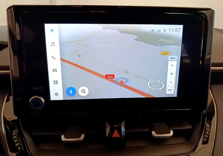 Écran tactile central affichant la navigation 3D dans l’habitacle d’une Toyota Corolla blanche hybride.