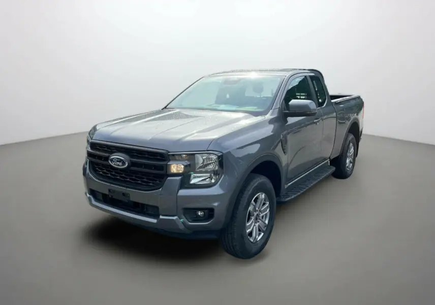 Ford Ranger gris carbone en 3/4 avant droit, avec marchepieds latéraux et calandre noire distinctive.