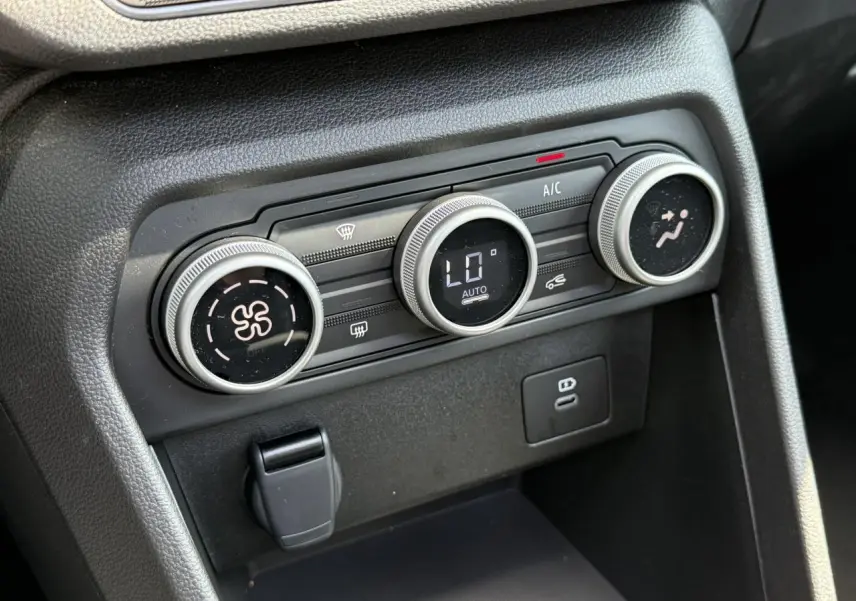 Gros plan sur les commandes de climatisation automatique de la Dacia Sandero Stepway Vert Cèdre 2025.