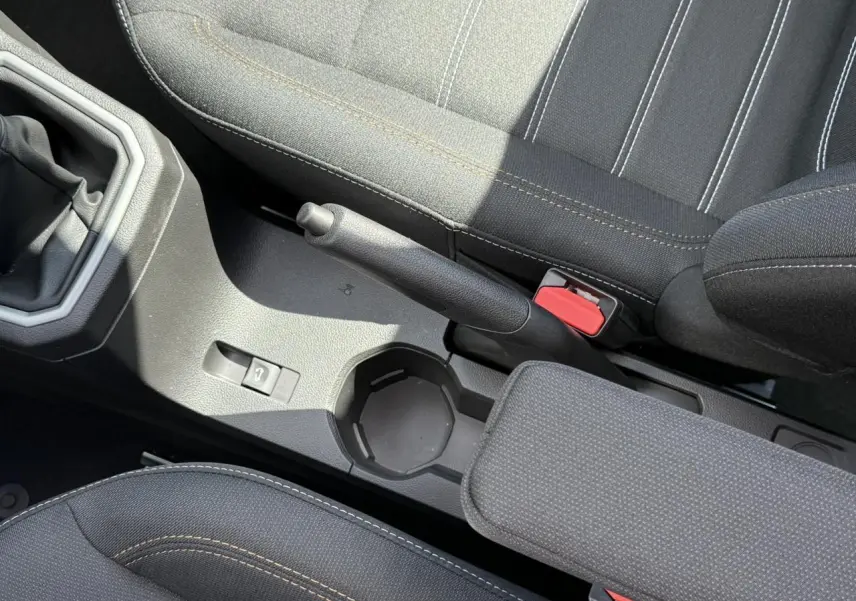 Vue rapprochée de la console centrale et frein à main de la Dacia Sandero Stepway 2025 avec sellerie noire et surpiqûres contrastées.
