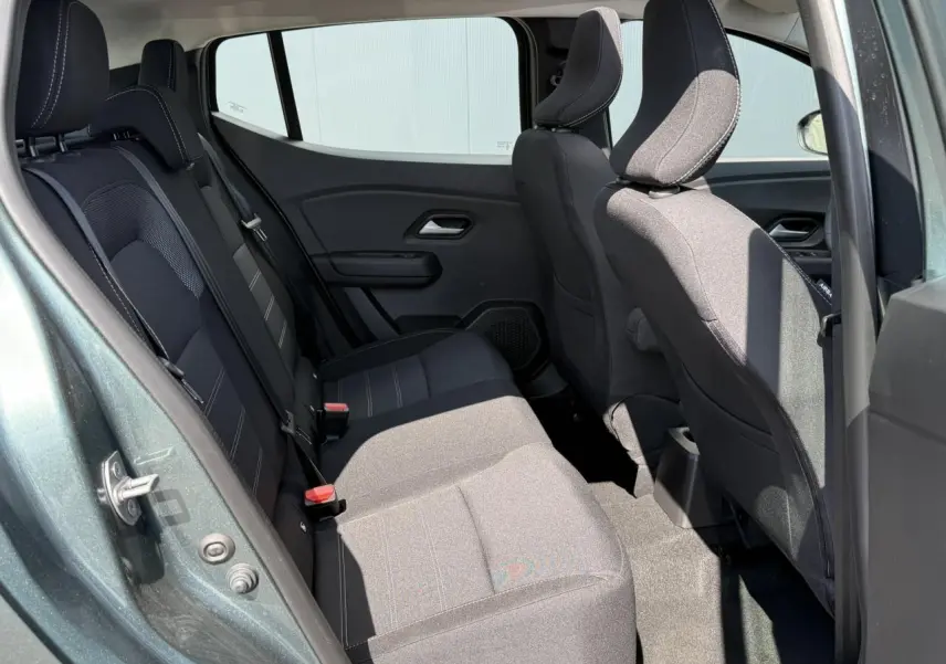 Vue côté gauche de l'habitacle arrière du Dacia Sandero Stepway Vert Cèdre, sièges tissu noir avec surpiqûres grises.