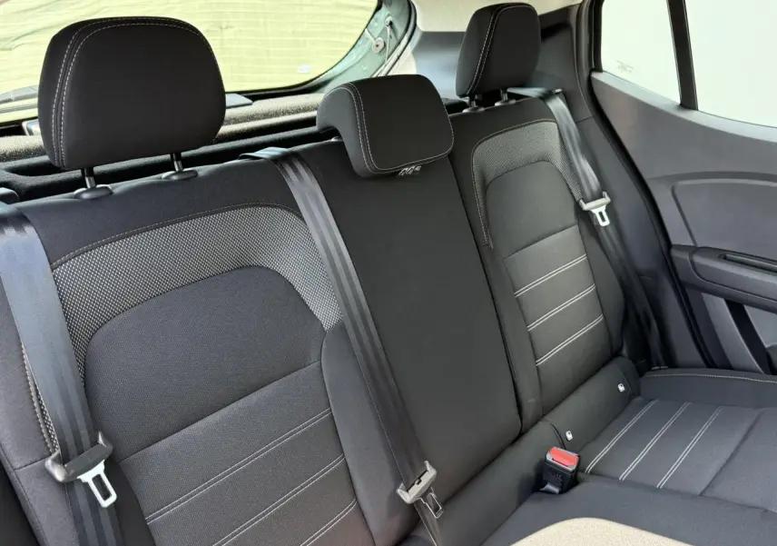 Vue intérieure de la banquette arrière noire avec appuie-têtes et ceintures de sécurité du Dacia Sandero Stepway 2025.