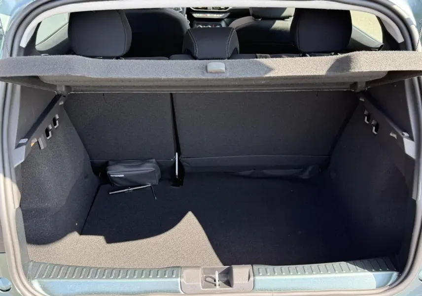 Coffre ouvert d'une Dacia Sandero Stepway Vert Cèdre, montrant l'espace de chargement et la tablette arrière.