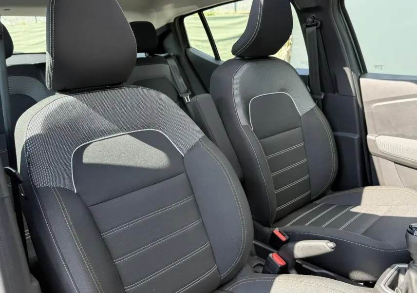 Gros plan sur les sièges avant noirs avec surpiqûres claires de la Dacia Sandero Stepway 2025, côté conducteur et passager.