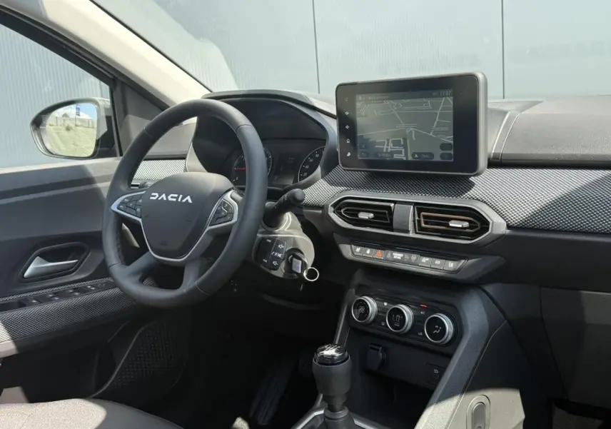 Vue intérieure côté conducteur du tableau de bord et volant Dacia Sandero Stepway 2025 avec écran tactile et commandes intégrées.