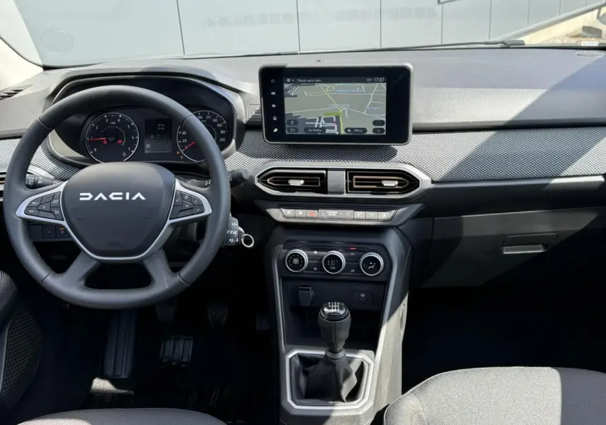 Vue intérieure centrée sur le tableau de bord et volant du Dacia Sandero Stepway 2025 avec écran tactile et boîte manuelle.