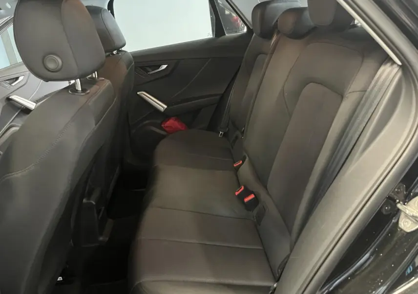 Vue intérieure côté droit des sièges arrière noirs en tissu de l'Audi Q2 2023 finition Design.