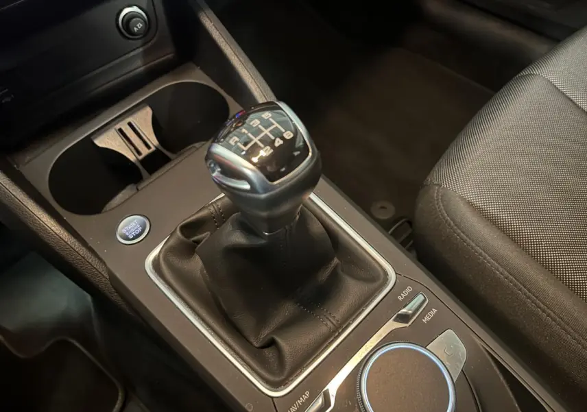 Gros plan sur la boîte manuelle noire et la console centrale de l'Audi Q2 1.0 30 TFSI Design 2023.