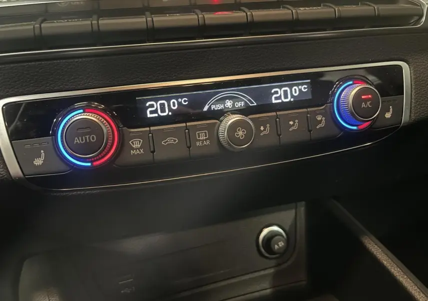 Vue rapprochée de la console centrale de l'Audi Q2 2023, affichant la climatisation automatique à 20°C.