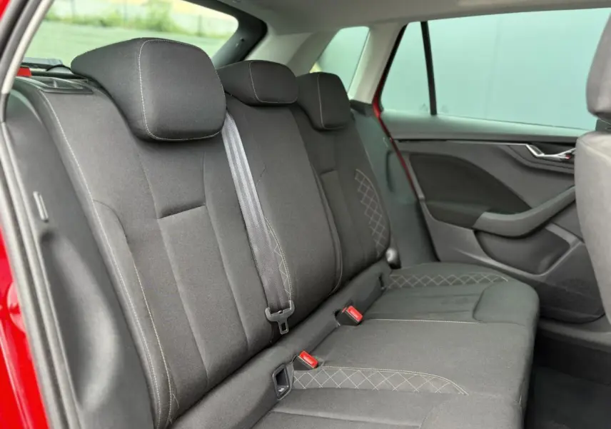 Vue latérale intérieure des sièges arrière noirs avec surpiqûres, dans un Skoda Kamiq Rouge Velvet 2024.
