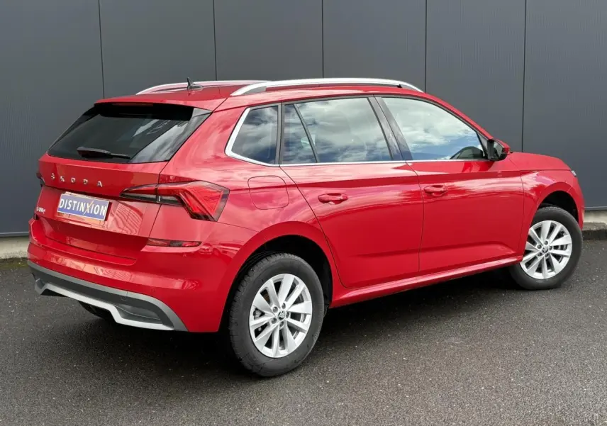 Vue 3/4 arrière droite d'un Skoda Kamiq rouge Velvet avec jantes alliage 16 pouces et vitres arrière surteintées.