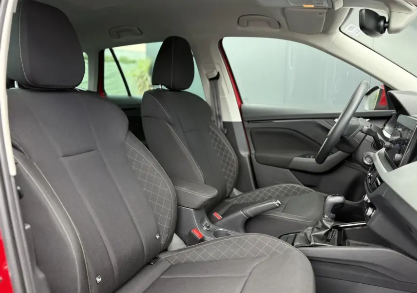 Intérieur du Skoda Kamiq rouge Velvet, vue côté droit sur les sièges tissu noirs et console centrale avec boîte auto.
