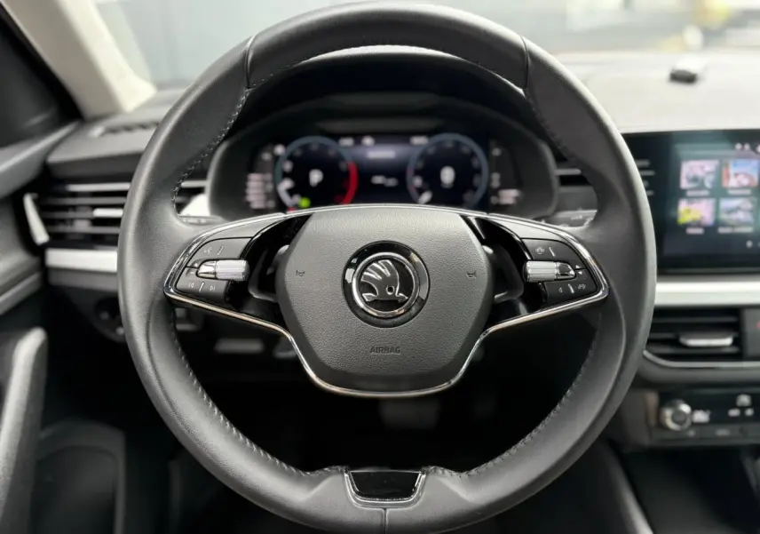 Vue rapprochée du volant cuir multifonctions de la Skoda Kamiq 2024 avec Digital Cockpit en arrière-plan.