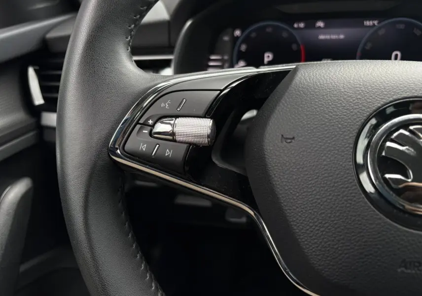 Gros plan sur le volant cuir multifonctions du Skoda Kamiq 2024, avec commandes audio et Digital Cockpit en arrière-plan.