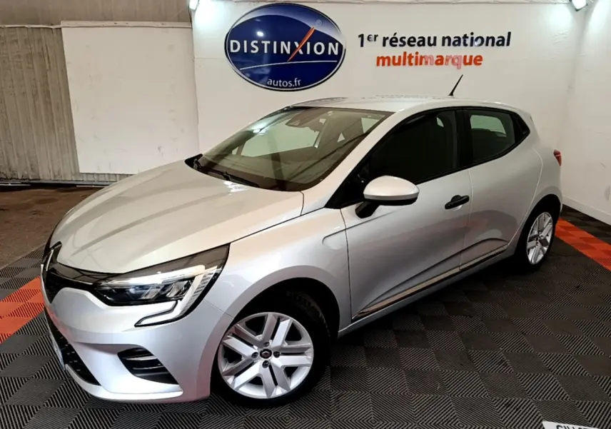 Renault Clio Business TCe 100 gris clair vue 3/4 avant droit dans un showroom avec logo Distinxion en arrière-plan