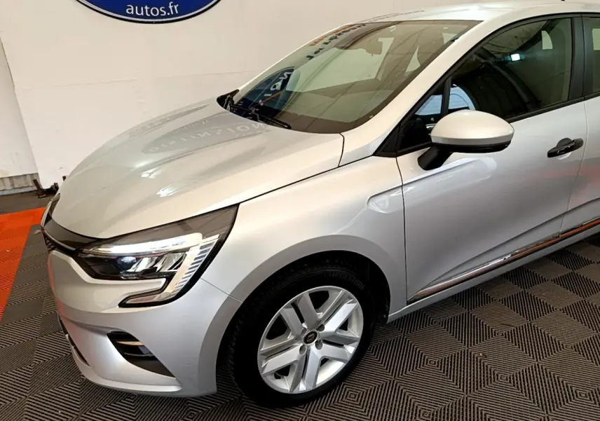 Renault Clio Business TCe 100 gris clair vue 3/4 avant droit, avec phares LED et jantes alliage visibles.