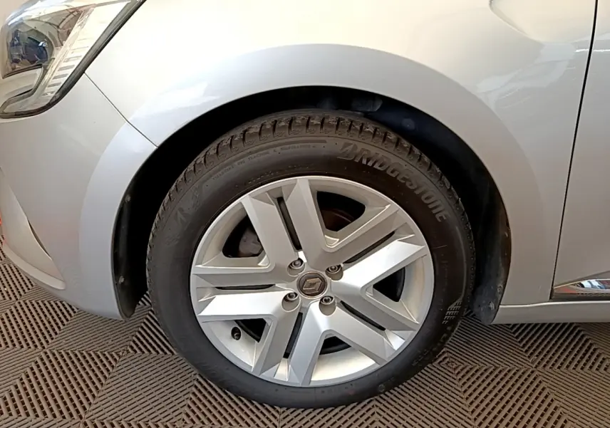 Gros plan sur la roue avant gauche d'une Renault Clio Business gris clair, avec jante alliage et pneu Bridgestone.