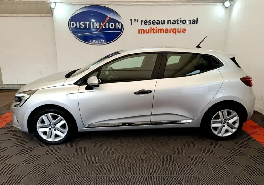 Profil côté gauche d'une Renault Clio Business TCe 100 gris clair, vue en intérieur sur fond de logo Distinxion.