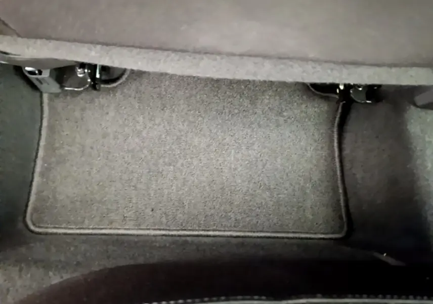 Tapis de sol gris foncé sous le siège arrière d'une Renault Clio Business TCe 100 de 2020.