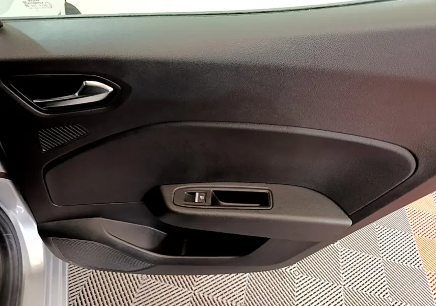 Porte intérieure côté gauche noire de Renault Clio Business TCe 100 2020, avec poignée argentée et commande de vitre électrique.