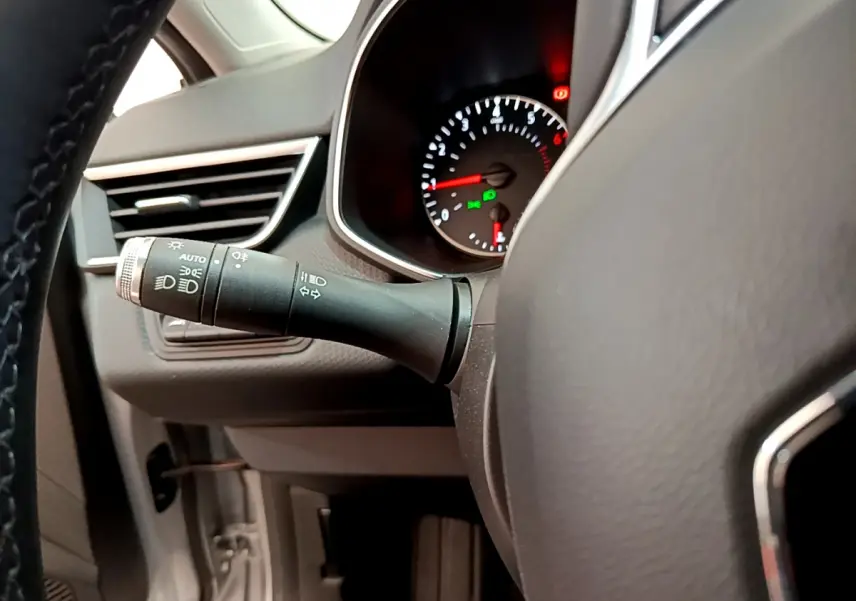 Gros plan sur la manette des phares et le tableau de bord noir de la Renault Clio Business TCe 100 2020.