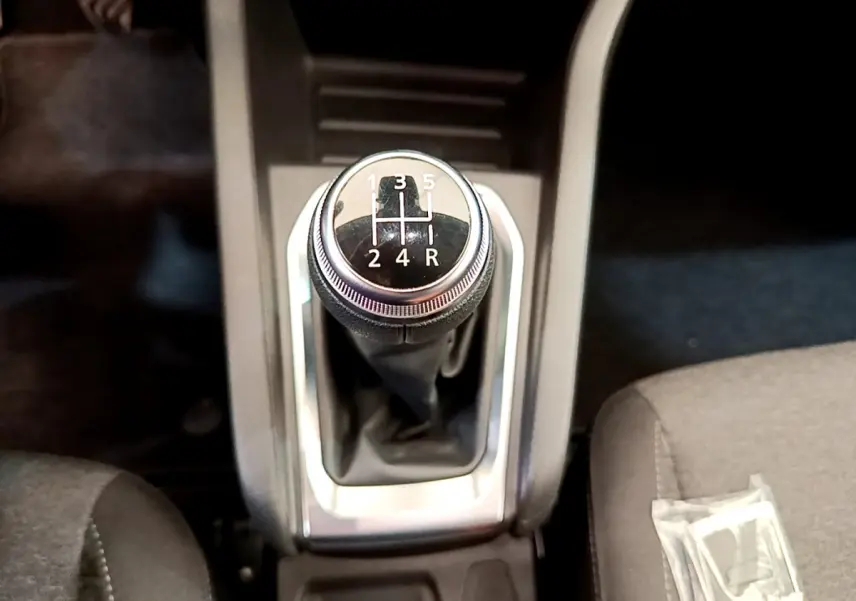 Le levier de vitesses manuel noir de la Renault Clio Business TCe 100 2020, vu de dessus entre les sièges gris.