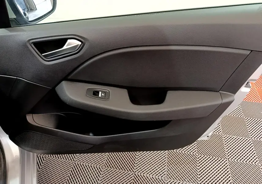 Vue intérieure côté gauche de la porte avant d'une Renault Clio Business TCe 100 2020, garniture noire avec poignée argentée.