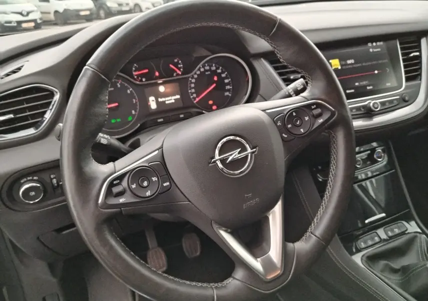 Vue rapprochée du volant en cuir noir de l'Opel Grandland X 2019 avec tableau de bord et console centrale visibles.