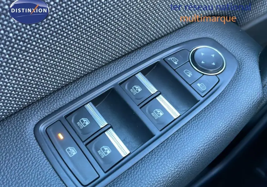 Gros plan sur les commandes des vitres électriques côté conducteur du Renault Captur rouge désir métal 2025 avec toit noir.