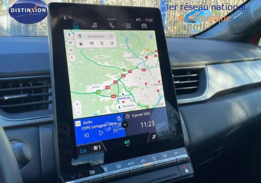 Vue rapprochée de l’écran tactile central du tableau de bord du Renault Captur rouge Désir Métal, affichant la navigation GPS.