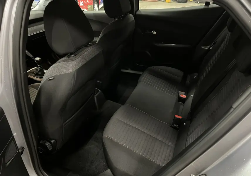 Vue intérieure côté droit des sièges arrière noirs du Peugeot 2008 gris alu, montrant la sellerie et la console avant.