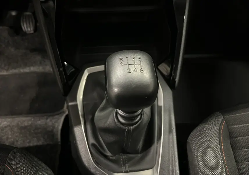 Gros plan sur le levier de vitesses manuel noir de la Peugeot 2008 Active Business 2020, intérieur tissu gris foncé.