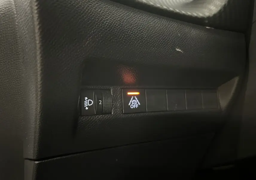 Gros plan sur les commandes intérieures noires du Peugeot 2008 Active Business, avec témoin d'alerte orange allumé.