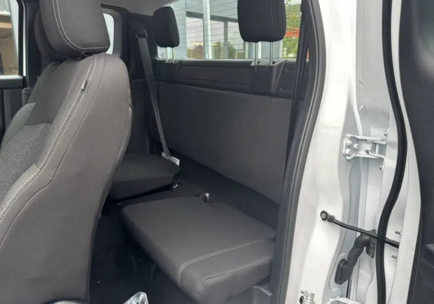Vue intérieure côté droit du Ford Ranger blanc glacier 2026, montrant la banquette arrière compacte et les sièges avant en tissu noir.
