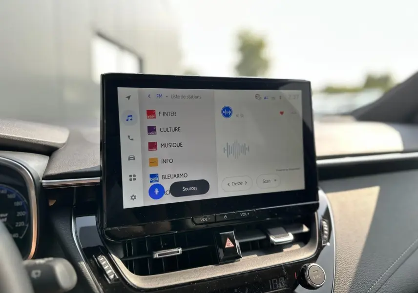 Écran tactile central de la Toyota Corolla Touring Sport 1.8 Hybrid 2025 affichant la liste des stations radio.
