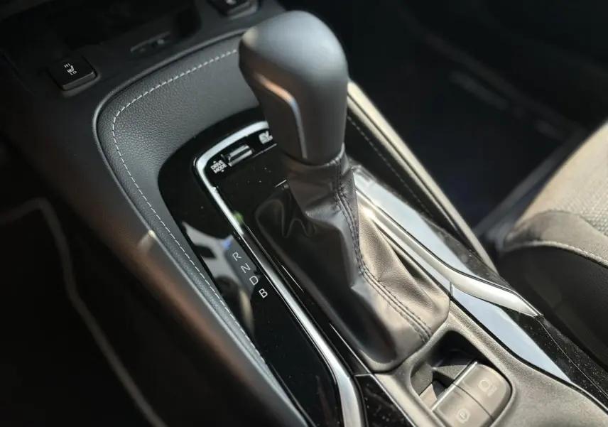 Le levier de vitesse automatique noir de la Toyota Corolla Touring Sport 1.8 Hybrid 2025 vu en gros plan intérieur.