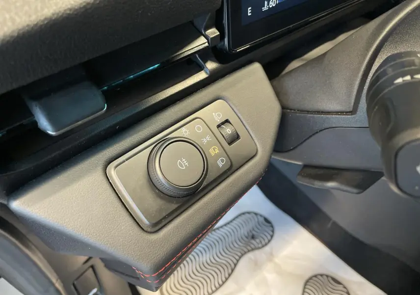 Gros plan sur la commande d’éclairage à gauche du volant dans l’habitacle noir du Ford Puma gris clair 2024.