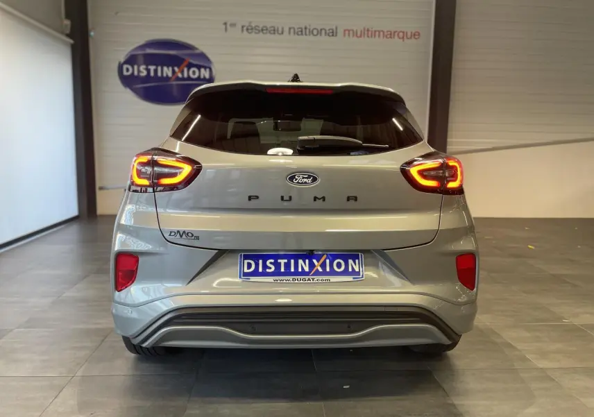 Vue arrière d'un Ford Puma gris clair 2024 avec feux LED allumés et logo distinctif sur porte de coffre.