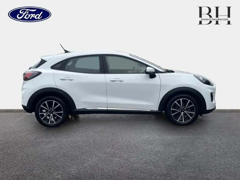 Vue de profil côté gauche d'un Ford Puma blanc Glacier avec jantes alliage et détails noirs contrastants.