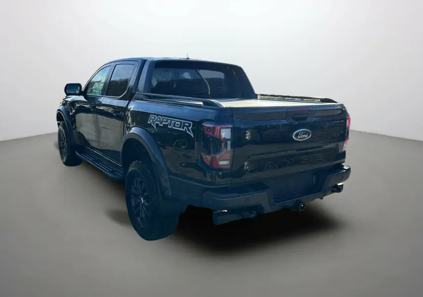 Ford Ranger Raptor noir absolu vu 3/4 arrière droit, avec logo Raptor sur la benne et jantes noires.