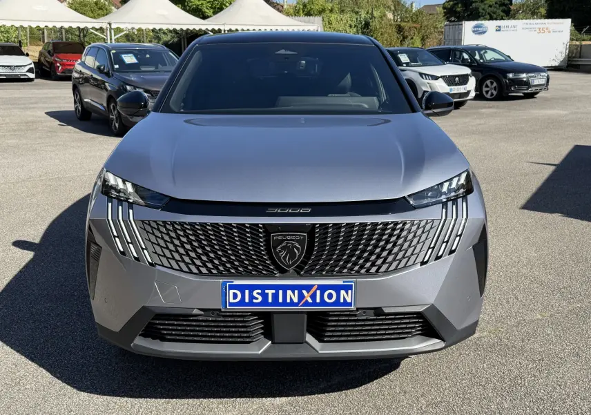 Vue frontale d'un Peugeot 3008 gris clair avec calandre noire et phares LED distinctifs en journée en extérieur.