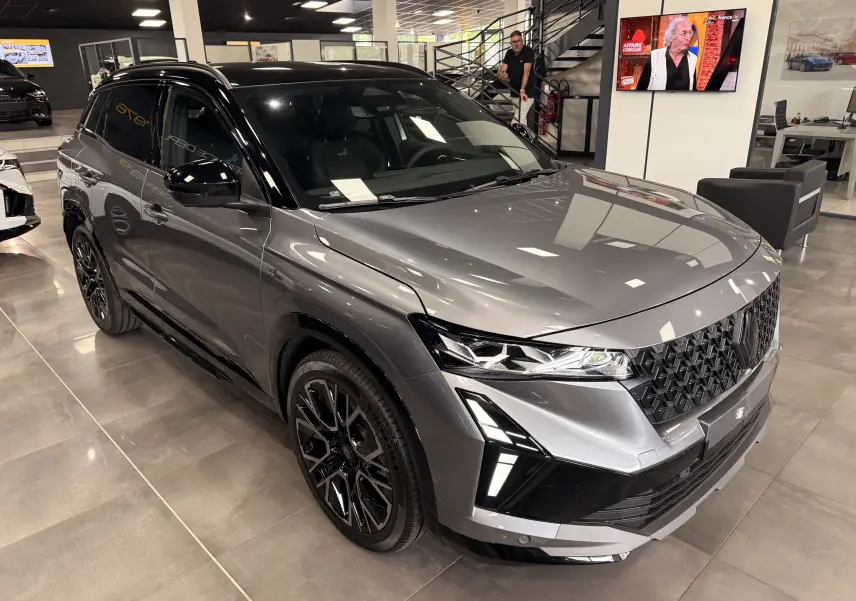 Renault Austral full hybrid gris schiste avec toit noir, vue 3/4 avant mettant en valeur ses optiques LED et jantes noires.